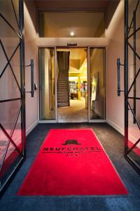 a red carpet in the entrance to a store at Hotel The Neufchatel in Brussels