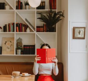 una mujer sentada en una mesa leyendo un libro rojo en The Masons Arms Hotel, en Louth