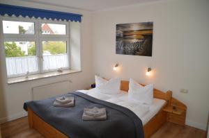 維特丁的住宿－Hotel Südstrand Amrum，一间卧室配有一张床,上面有两条毛巾