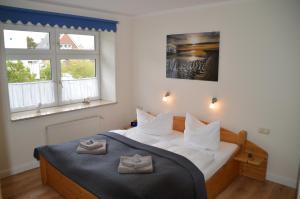 una camera da letto con un letto con due asciugamani sopra di Hotel Südstrand Amrum a Wittdün