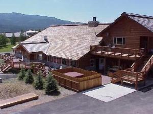 uma grande casa de madeira com um alpendre e um deque em The Bull Moose Lodge em Alpine