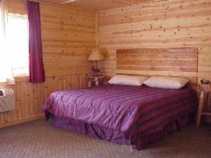 a bedroom with a bed in a log cabin at The Bull Moose Lodge in Alpine