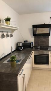 a kitchen with a sink and a microwave at In der Luft Obergeschoss in Wesel