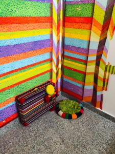 una pared de color arco iris con una maleta y un juguete en B&B Sangro, en Atessa