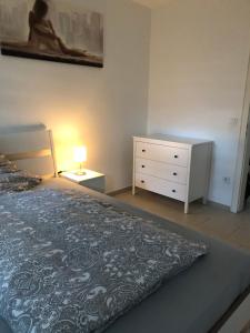 a bedroom with a bed and a dresser with a lamp at In der Luft Obergeschoss in Wesel