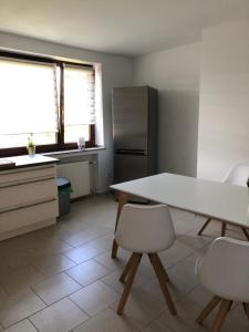 a kitchen with a table and two chairs and a refrigerator at In der Luft Obergeschoss in Wesel +4 photos