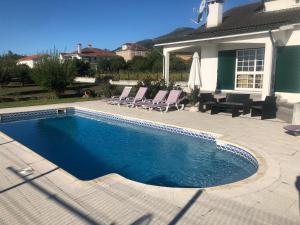 a swimming pool in front of a house at Quinta do Paulo in Caramulo