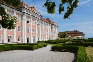 un grande edificio rosa con giardino di fronte di Lakeview Penthouse a Meersburg