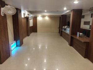 an empty hallway in a hotel with a fan at Starlit Select Nirvana in Varanasi