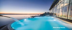 una grande piscina di fronte ad un edificio con acqua di Lakeview Penthouse a Meersburg