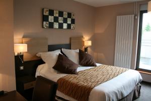 1 dormitorio con 1 cama grande y 2 almohadas en Auberge de la Petite Ferme, Super-Besse Est, The Originals Relais (Qualys-Hotel), en Besse-et-Saint-Anastaise