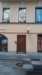 un edificio con una puerta marrón y tres ventanas en Guest House Geralda on Nevskiy, en San Petersburgo