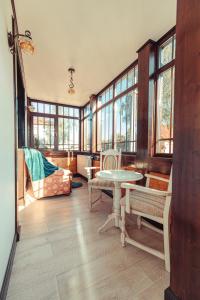 a living room with a table and chairs and windows at Vila Genia in Câmpulung Moldovenesc
