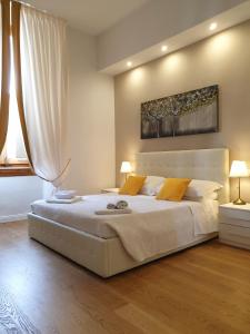 una camera da letto con un grande letto bianco con due lampade di Pink Wolf a Firenze