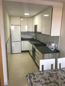 a kitchen with white cabinets and a white refrigerator at Atico con piscina privada y vistas al mar in Vera