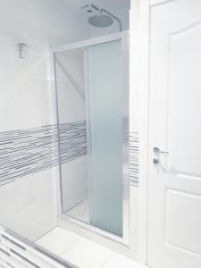una doccia con porta in vetro in bagno di Pink Wolf a Firenze