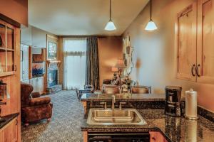 a kitchen with a sink and a living room at Big Sky Resort Village Center in Big Sky