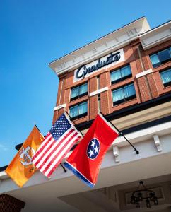 three flags hanging from the front of a hotel at Graduate Knoxville in Knoxville