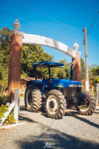 um tractor azul estacionado em frente a um arco em Hotel Fazenda Casarão do Vale Hotel em Massaranduba