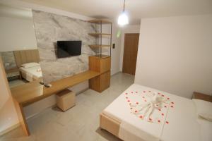 sypialnia z łóżkiem i telewizorem w pokoju w obiekcie Hotel Four Islands w mieście Ksamil