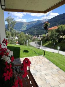 eine Terrasse mit einem Tisch mit Blumen und Aussicht in der Unterkunft Bergperle Apartments & Mountain Sport in Fliess