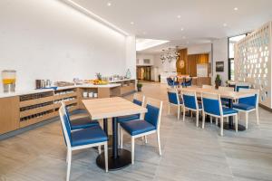 a dining room with tables and blue chairs at Coast Tsawwassen Inn in Delta