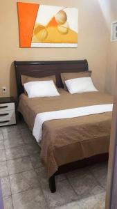 1 dormitorio con 2 camas y un cuadro en la pared en Casa Azul Triplex en Cabo Frío