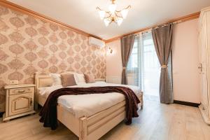 een slaapkamer met een bed en een kroonluchter bij Vila Genia in Câmpulung Moldovenesc