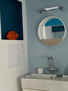 a bathroom with a sink and a mirror at Maisonnette de la mer in Hermanville-sur-Mer