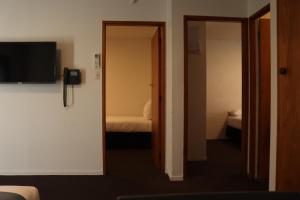a room with two doors and a television on a wall at Victoria Apartments in Hamilton