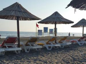 a group of chairs and umbrellas on a beach at Kollari Apartments in Ulcinj