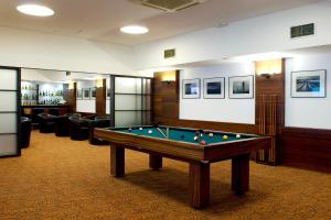 a billiard room with a pool table and chairs at Leziria Parque Hotel in Vila Franca de Xira