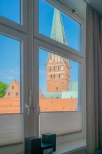 a window with a view of a tower and buildings at Stadtblick in Lüneburg