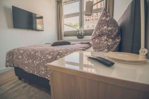 a bedroom with a bed and a desk and a window at Stadtblick in Lüneburg