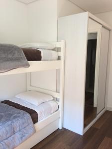 カネラにあるApartamento Boulevardの二段ベッド2台と鏡のある寝室