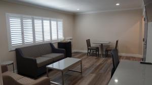 a living room with a couch and a table at Sea Breeze Inn - LAX Airport, Los Angeles in Inglewood