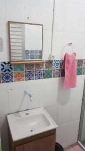 y baño con lavabo y espejo. en Residencial Praia da Daniela, en Florianópolis
