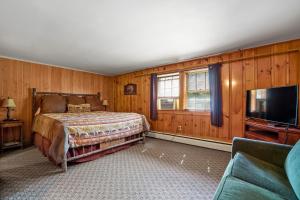 1 dormitorio con 1 cama y TV de pantalla plana en Whitney's Inn, en Jackson