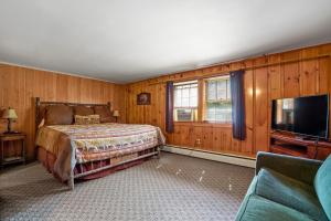 a bedroom with a bed and a flat screen tv at Whitney's Inn in Jackson