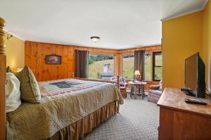 ein Hotelzimmer mit einem Bett und einem TV in der Unterkunft Whitney's Inn in Jackson