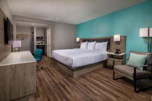 um quarto de hotel com uma cama e uma cadeira em Travelodge by Wyndham LAX em El Segundo