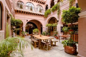 an outdoor patio with tables and chairs and plants at Selina San Miguel de Allende in San Miguel de Allende