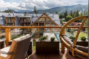 a balcony with chairs and a view of a building at APARTHOTEL ROYAL RESORT SPA Zakopane in Zakopane