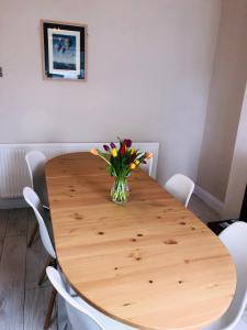 een houten tafel met een vaas met bloemen erop bij St Marks in Northfleet