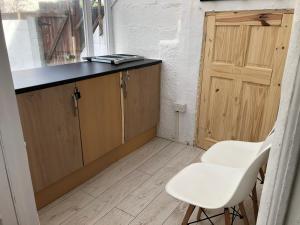 a small kitchen with two white chairs and a counter at St Marks in Northfleet