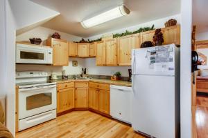 a kitchen with white appliances and wooden cabinets at Estes Park Condos in Estes Park