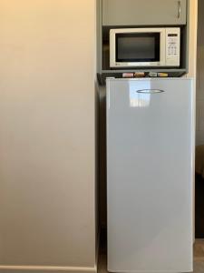 a white refrigerator with a microwave on top of it at Temuka Motel in Temuka