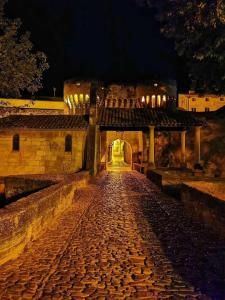 a cobblestone path leading to a building at night at STUDIO PRIVATIF CLIMATISÉ , TERRASSE ET PiSCINE in Pernes-les-Fontaines