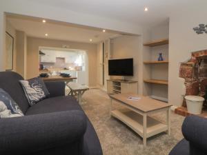 una sala de estar con un sofá y una mesa en Hillcroft Cottage, en Teignmouth