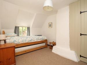 Un pat sau paturi într-o cameră la Forge Cottage
